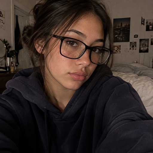 a selfie teen girl half filipina half irish, big black rectangular glasses, dark brown hair in a low messy bun, chocolate brown eyes, light tan skin, soft freckles. wearing an oversized hoodie. (her name is claire)